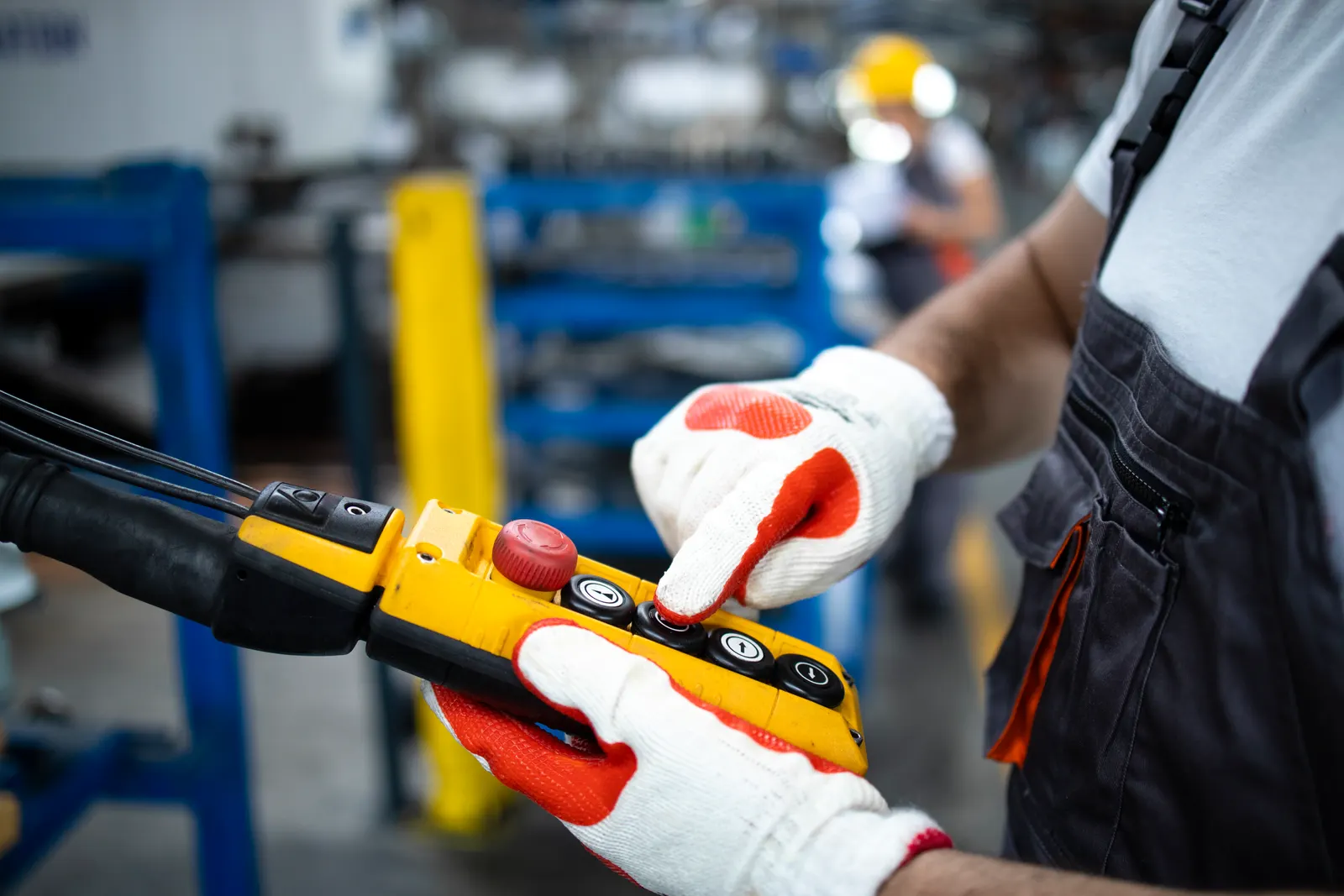 Factory worker operating industrial machinery in a production hall