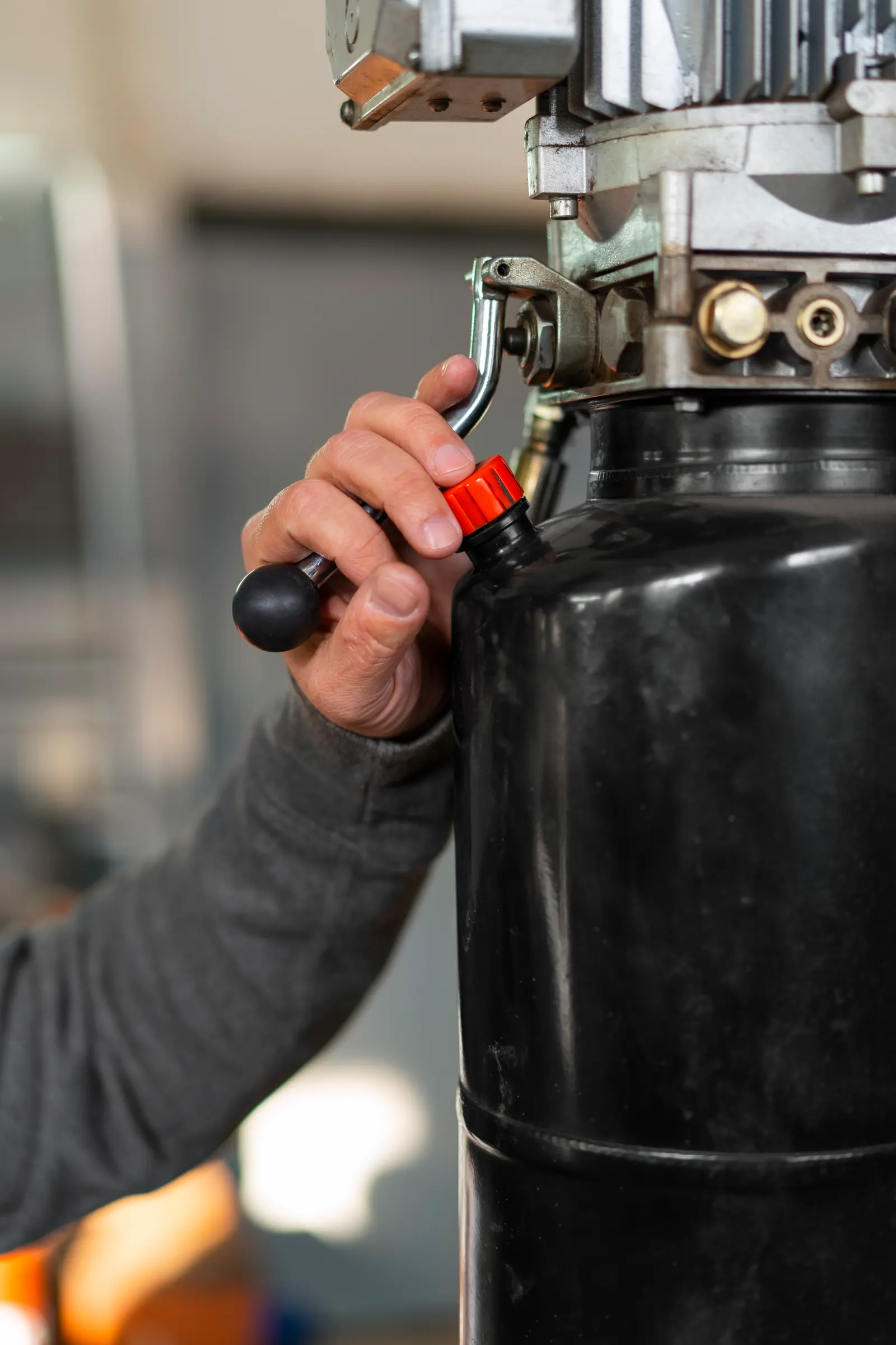 Technician servicing a piston air compressor in the shop